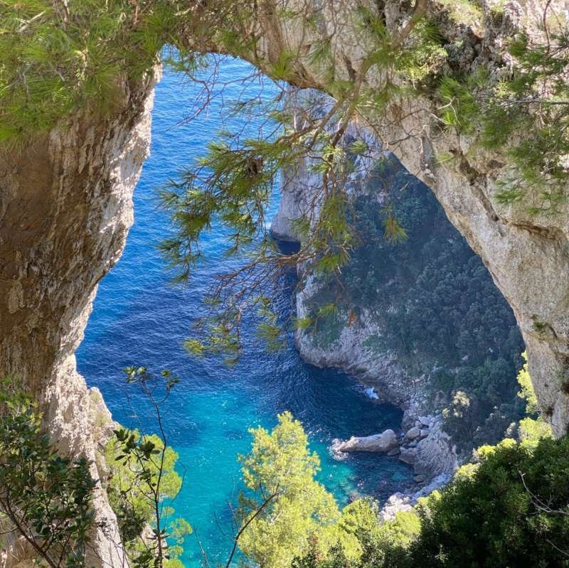 Arco Naturale rock arch framing a turquoise cove on the east coast of Capri