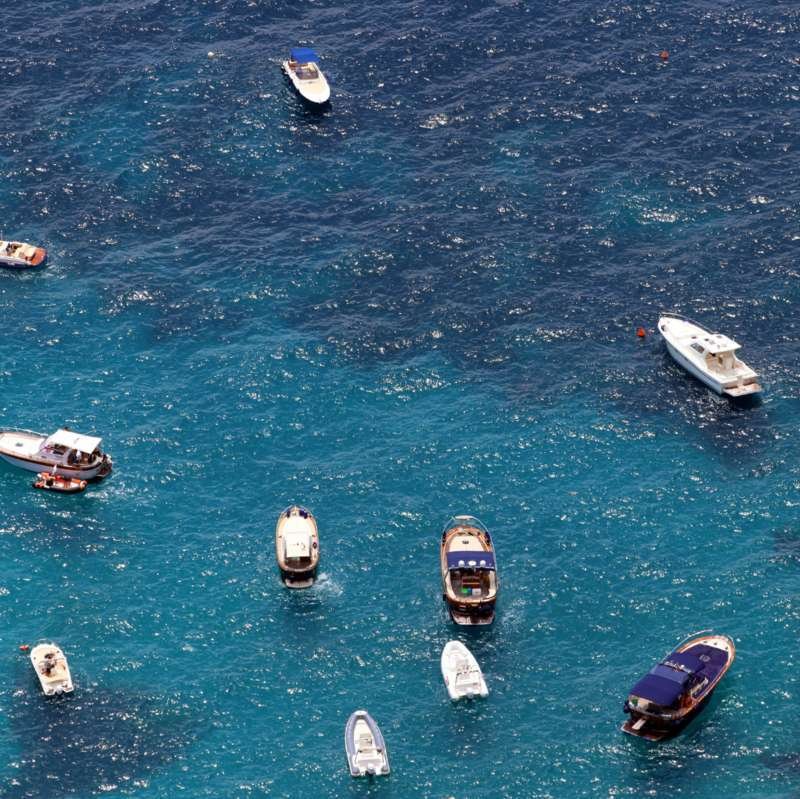 Aerial view of small boats anchored on sparkling blue sea off Capri