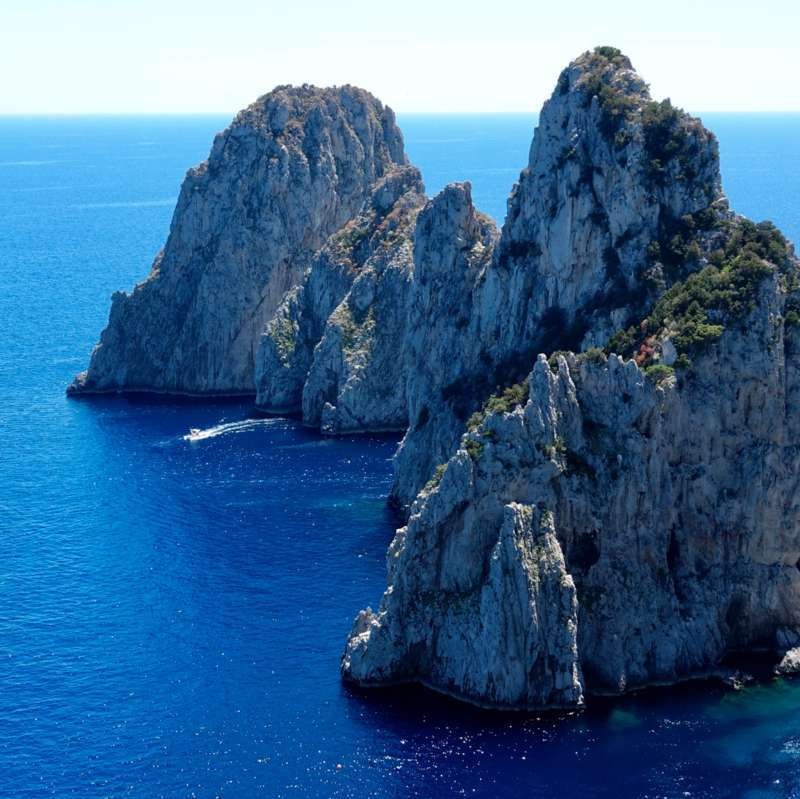 Faraglioni rock formations of Capri seen from the clifftop path above deep blue sea